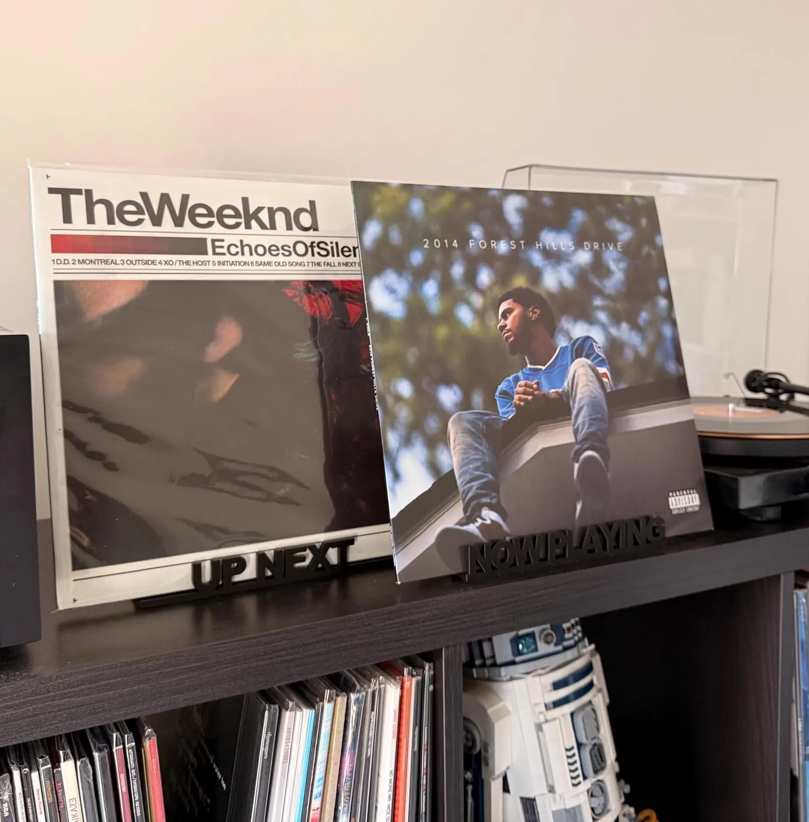 Rekkid Now Playing and Up Next record display stands on a shelf